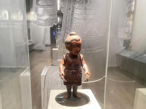 石包丁で稲穂をつむ弥生の女性